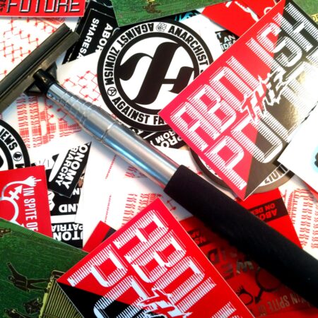 a messy pile of Municipal Adhesives stickers with a Stick Em Up Pole laid atop