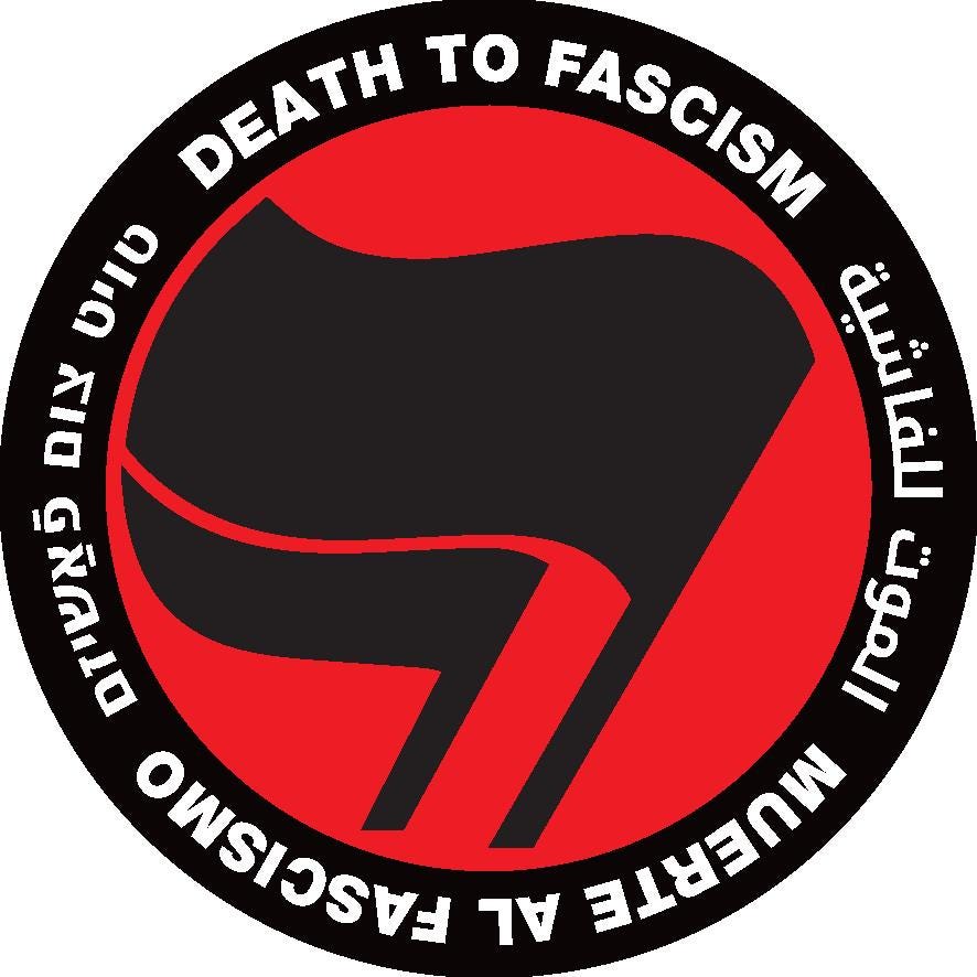 A thick black circle containing the words: "Death to Fascism, Muerte al Fascismo, الموت للفاشية, טויט צום פֿאַשיזם, ." Inside this circle are two black flags arranged over a red field recognizable as the antifascist logo.