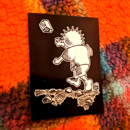 A sticker atop a fuzzy plaid background. The stickers show the refugee cartoon boy Handala, characteristically barefoot, throwing a rock at some unseen Israeli tank.