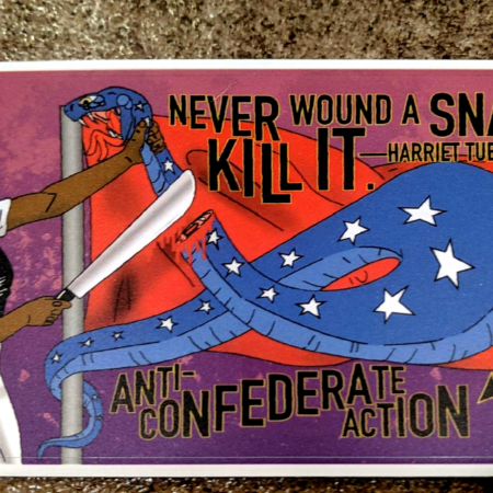 On a background of concrete, an Anti-Confederate Action sticker: Harriet Tubman stands mean-mugging a snake she has severed the head from with a machete. The snake is curled and doubled over on itself, having been unraveled from a flagpole upon which is a red flag, giving the impression of a confederate battle flag. The quotation, "Never wound a snake. Kill it. - Harriet Tubman" appears above the flag. The words, "Anti-Confederate Action" appear below in black with yellow border. There are three antifascist arrows in the same colors in the bottom right corner.