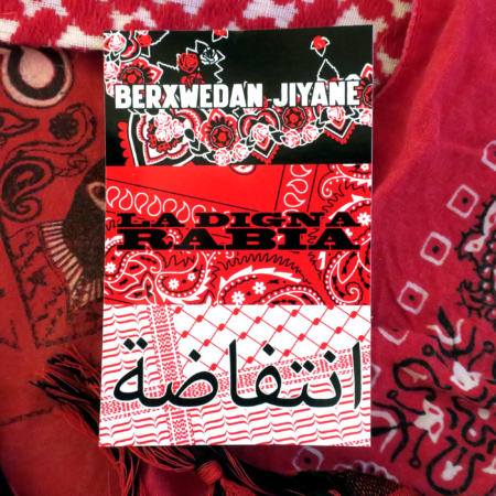 Across a backdrop of a couple of keffiyeh patterned cloths and two EZLN paliacates, a white black and red sticker. These stickers have a triptych of cloths: a simplified Kurdish floral pattern with the words "Berxwedan Jiyane," a paliacate pattern with the words "La Digna Rabia," and a keffiyeh pattern with the words "نتفاضة"